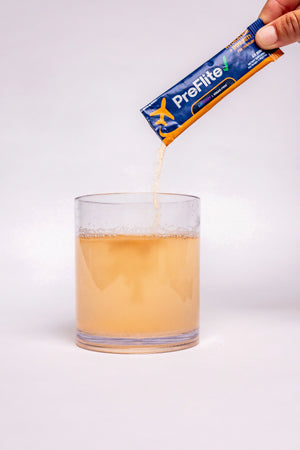 Pre Flite Airberry powder being mixed into a glass of water for travel hydration